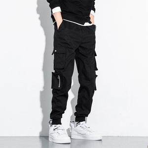 Straight Leg cargobroek in zwart, stijl 1, vooraanzicht met een zwarte sweater, dijzakken en een ritsdetail
