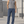 Blue straight leg athletic pants on a man outdoors, front view showing the elastic waist and the thigh logo