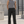 Black straight leg athletic pants worn front view, hands in the side slash pockets, on a concrete terrace