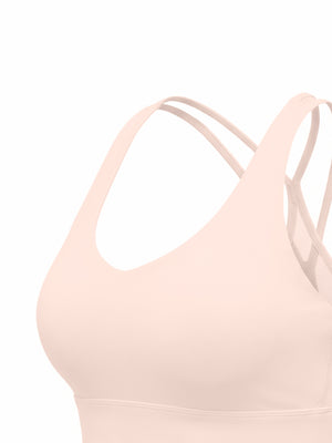 Three-quarter view of the pink sports bra, a thin strap running from the shoulder to the back cross