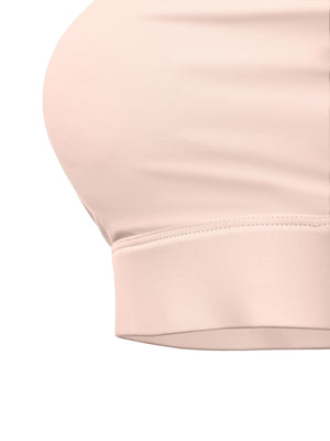 Close-up of the elastic under-band, a wide flat hem finishing the pink knit beneath the bust