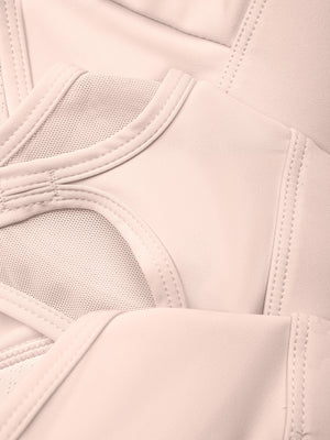 Inside the light pink bra, the mesh back panel and the lining that holds each cup pad in place