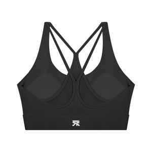 Back of the black sports bra laid flat, thin straps crossing in a star over the mesh panel and padded cups