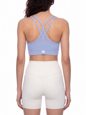 Back view on the model in lavender, the double straps crossing between the shoulder blades