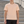 Man in the Light Pink Stretch Athletic T Shirt, front view on outdoor steps, small chest wordmark