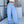 Blue pinstripe Y2K pants worn on a street, front view with a white crop top, labelled without logo