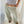 Light sage green pull-on pants with an elastic waistband, close front view worn with a striped top
