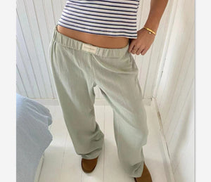 Light sage green pull-on pants with an elastic waistband, close front view worn with a striped top