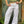 White eyelet embroidered wide leg pants worn with a green tank top, full front view in a doorway