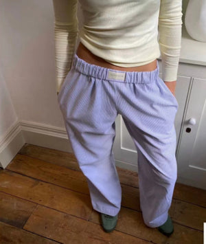 Lavender purple striped baggy pants with an elastic waist, front close-up worn with a cream top