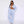 Blue pinstripe pants worn with the matching oversized striped shirt and a white bralette, front view