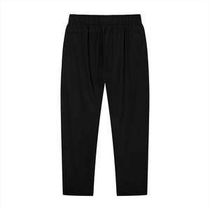 Black workout pants laid flat from the back, elastic waistband and tapered legs to the ankle