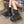 Model seated wearing the Tech Wear Boots Black, side view of the high platform sole and buckled strap