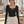 Model in a pilates studio wearing the black long sleeve bodysuit, front view with the CYBER wordmark
