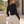 Model looking back over her shoulder in the black bodysuit, long sleeves and heather sweatpants outdoors