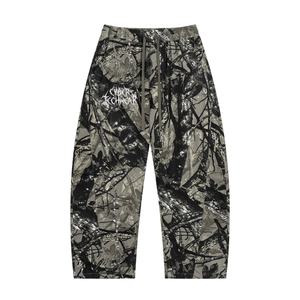 Grey tree camo trousers laid flat from the front, the barrel leg curving out through the thigh