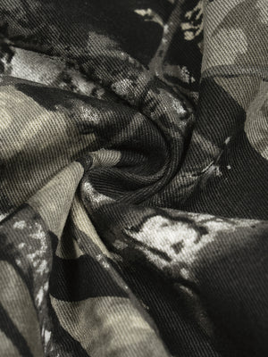 The camo fabric twisted to show its texture, a 340 gsm woven cotton of moderate thickness