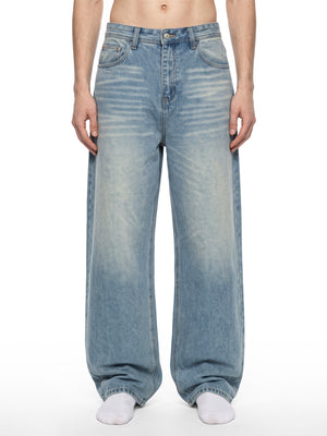 Modell i Vintage Wash Baggy Y2K Jeans, framifrån från midja till fötter, lösa vida ben och urtvättade slitningar