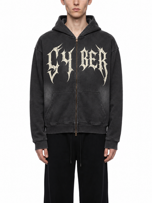 A model wears the black hoodie with the hood down, the body cut short and square at the hem