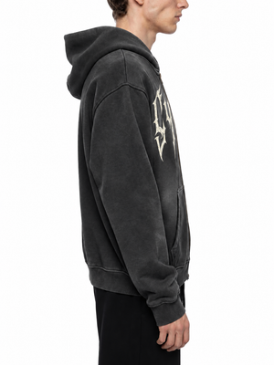 Close side view of the black hoodie, the faded wash lifting the colour across the shoulder