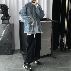 Full length view of the light blue denim jacket with wide black trousers and sneakers in a studio