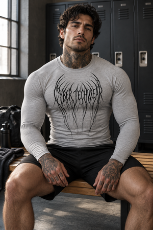 A tattooed man sits on a bench in the flecking gray compression shirt and black shorts, front view