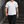 Man stepping down concrete stairs in the White Regular Fit Gym Tee and black cargo pants, front view