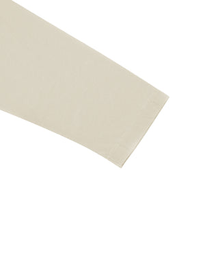 Straight cuff and sleeve of the apricot tee, showing the even midweight knit and its clean edge