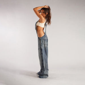 Zip Denim Y2K Overalls in mid blue, side view showing the open side and the wide leg falling to the floor
