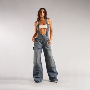 Zip Denim Y2K Overalls in mid blue, front view with the full-length front zip and a cream bralette