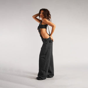 Zip Denim Y2K Overalls in washed black, side view of the open sides worn with a black bandeau