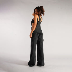 Zip Denim Y2K Overalls in washed black, three-quarter back view of the straps and wide leg