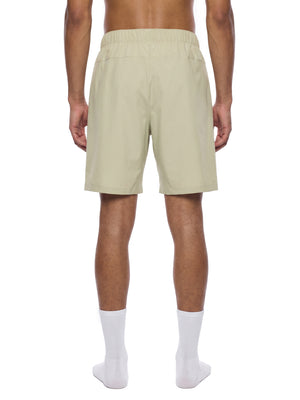 Back view of the Bean Green zip pocket basketball shorts on a model, wide elastic waistband
