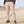 Khaki tactical cargo pants worn by a man standing on sandy ground, front view with flap pockets on both thighs