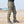 Green tactical pants in three-quarter front view outdoors, large thigh cargo pocket and straight leg to the ankle