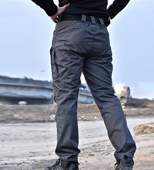Back view of the gray tactical cargo pants, hands on the hips, back pockets and straight leg down to the shoes