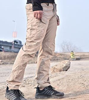 Khaki cyberpunk pants on a man walking, side view of the thigh cargo pocket and the belt loops at the waistband