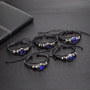 Five Zodiac Glow Y2K Bracelets laid out on a dark ribbed desk, each one with a different zodiac sign