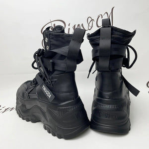 Back view of the Tech Wear Boots Black pair, pull tabs, crossed straps and the thick ridged platform heel